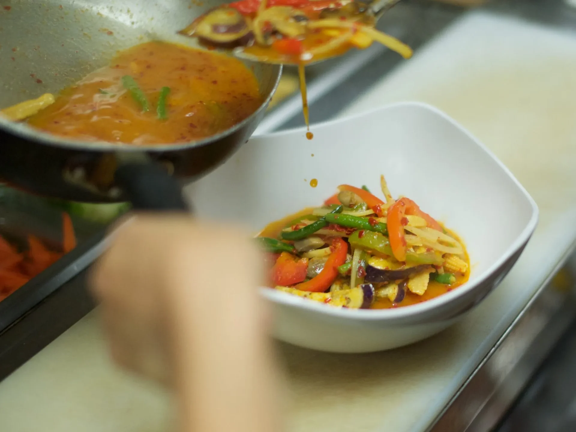 Wok flame stir frying fresh vegetables and Thai basil